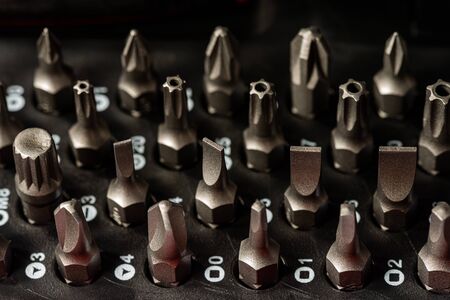 Macro photography of a set of heads for screwdriver on a dark background