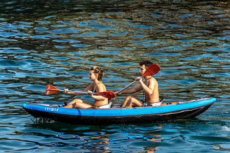 GULF OF LA SPEZIA, LIGURIA, ITALY - JULY 21, 2019: young couple, a man and a woman paddle in the blue sea on an inflatable kayak. Gulf of La Spezia, Liguria, Italy, Europeのeditorial素材