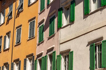Facade of generic houses with many windows and shutters in a street in Trentino Alto Adige, Italy, Europeの写真素材