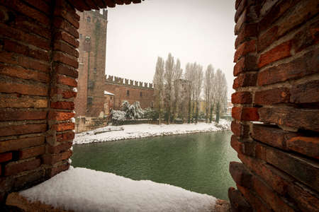 Verona. Castelvecchio (Old Castle) and River Adige seen from the Ponte Scaligero (medieval bridge) in winter while it snows. UNESCO world heritage site, Veneto, Italy, Europeのeditorial素材