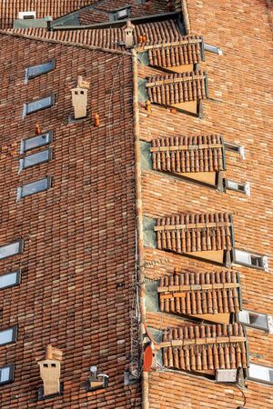 Pantiles. Closeup of an old house roof with tiles made from clay (Coppo in Italian language), skylights and dormers, seen from above in Bologna city, Emilia-Romagna, Italy, Europeの写真素材