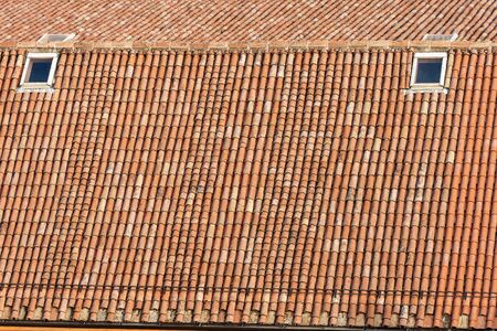 Pantiles. Closeup of an old house roof with tiles made from clay (Coppo in Italian language), and skylights, seen from above in Bologna city, Emilia-Romagna, Italy, Europeの写真素材