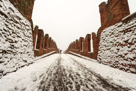 Ancient Scaligero bridge of Castelvecchio in winter while it snows. Old castle in Verona, UNESCO world heritage site, Veneto, Italy, Europeのeditorial素材