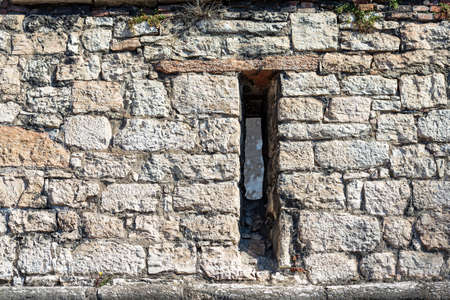 Close-up of a medieval castle wall with an arrowslit or loophole. Castello del Buonconsiglio or Castelvecchio in Trento city. Trentino Alto Adige, Italy, Europeのeditorial素材