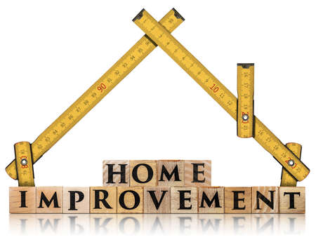 Yellow wooden folding ruler in the shape of a house and the text Home Improvement, made of wooden blocks, isolated on white backgroundの写真素材