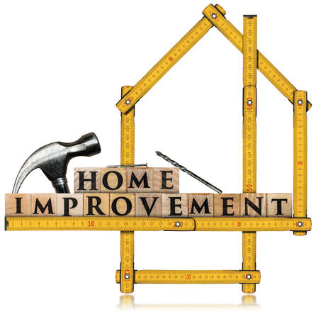 Text Home Improvement, made of wooden blocks and a wooden yellow folding ruler in the shape of a house. Isolated on white backgroundの写真素材