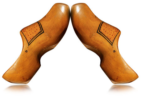 Closeup of wooden clogs made in Netherlands, isolated on white background with reflectionsの写真素材