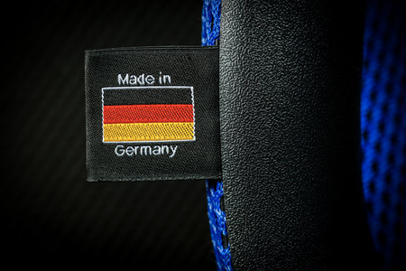 Extreme closeup of a made in Germany label with German flag, sewn on a black fabric. Macro...