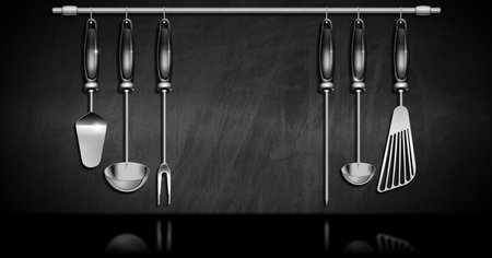 3D illustration of a set of kitchen utensils made of stainless steel and black plastic on a blackboard with copy space.の写真素材
