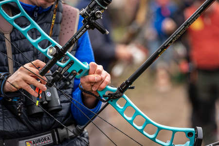 Close-up of an archer holding his compound hunting bow as he nocks the arrow. Preparation and concentration phase before archery.のeditorial素材