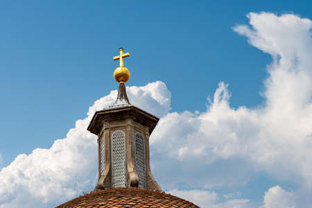 Basilica of Santo Spirito (1444-1487) in Florence downtown, Tuscany, Italy, Europe. Detail of the dome with lantern and golden cross on blue sky with clouds.の写真素材
