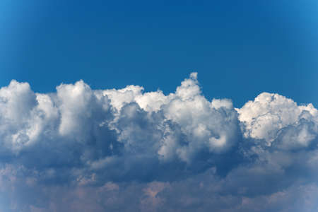 Beautiful storm clouds, cumulus clouds or cumulonimbus against a clear blue sky. Full frame,...