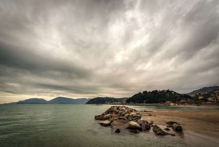 Beach and sea of the town of Lerici in winter, tourist resort in the Gulf of La Spezia, Liguria, Italy, Europe. On the horizon the San Terenzo village and the Porto Venere or Portovenere town.の写真素材