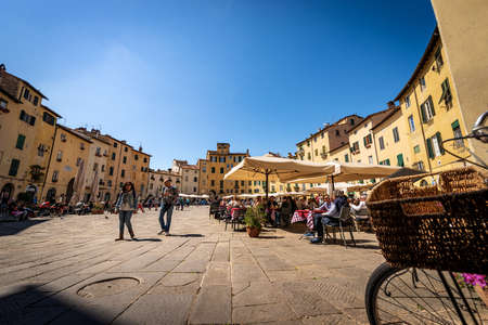 Piazza dell'Anfiteatro in Lucca downtown (Amphitheater Square). Tourists and locals visit the ancient elliptical city square. Tuscany, Italy, Europe.のeditorial素材