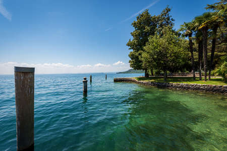 Coastline in front of the small town of Garda, tourist resort on the coast of Lake Garda (Lago di Garda). Beautiful bay and public park. Verona province, Veneto, Italy, Europe.の写真素材