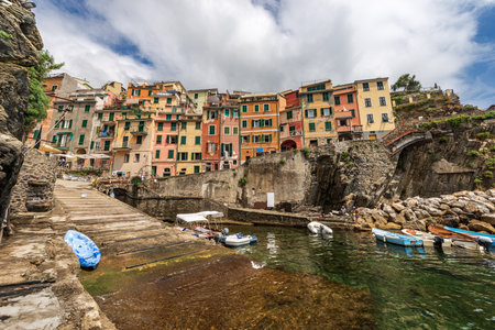The famous Riomaggiore village with small boats moored in the port, Cinque Terre National Park in Liguria, La Spezia, Italy, Europeの写真素材