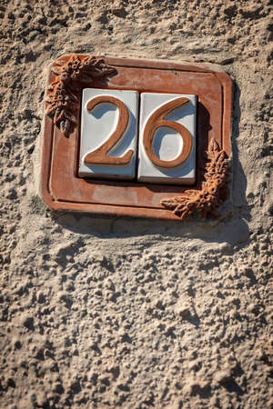 Close-up of house number 26 (twenty-six) on a concrete wall in the small village of Tellaro. Liguria, Italy, Europeの写真素材