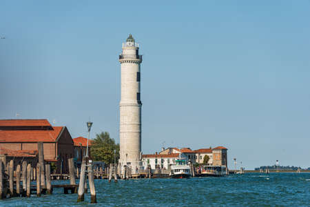 The ancient lighthouse of the island of Murano, famous for the production of artistic glass, with the Vaporetto station called Murano Punta Faro, Venice Lagoon, Venice, Veneto, Italy, Europe.の写真素材