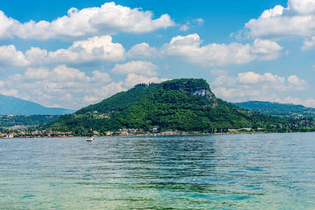 The hill called Rocca di Garda on the coastline of Lake Garda (Lago di Garda). Verona province, Veneto, Italy, southern Europe. On horizon the mountain range of Monte Baldo.の写真素材