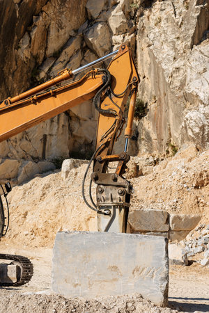 Orange tracker excavator with the jackhammer in a marble quarry (Carrara white marble) in the Apuan Alps (Alpi Apuane). Tuscany, (Toscana), Italy, Europeの写真素材