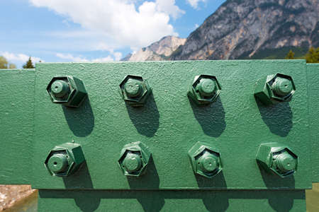 Close up of a girder of a green bridge in mountain with eight boltsの写真素材