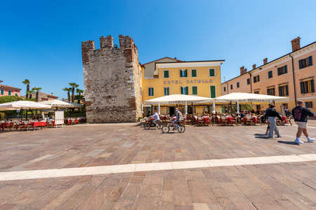 Downtown of Bardolino village. Promenade on the coast of Lake Garda with the medieval tower and restaurants, pizzerias and bars. Verona province, Veneto, Italy, Europeのeditorial素材