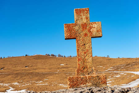 Ancient religious cross in red and orange stone, in a rural scene, Regional Natural Park of Lessinia Plateau (Altopiano della Lessinia), Verona province, Bosco Chiesanuova municipality, Italy, Europe.の写真素材