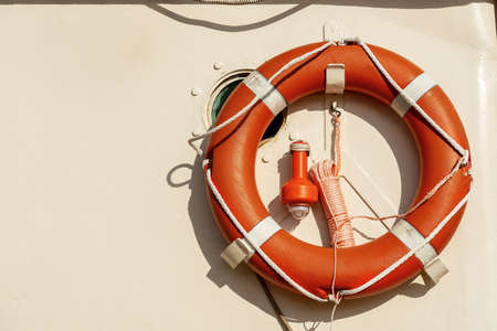 Close-up of an orange life buoy with an emergency light for localization on a boat deck with copy space.の写真素材
