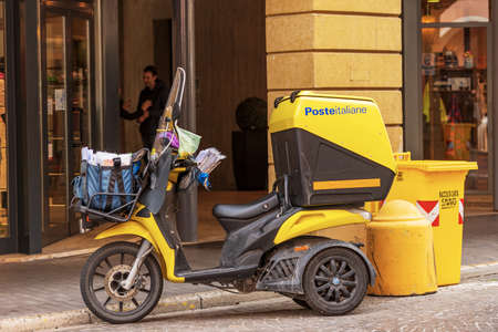 Close-up of an orange and black motorbike of the Italian Post Office (Poste Italiane), parked in the historic center of a small italian town, Veneto, Italy, Europe.のeditorial素材