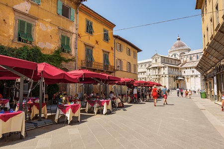 Tourists and outdoors restaurants in Pisa downtown, on background the Cathedral of Santa Maria Assunta, Piazza dei Miracoli (Square of Miracles), Tuscany, Italy, Europe.のeditorial素材