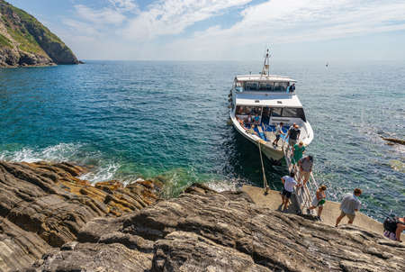 Ferry with tourists docked in front of the small village of Riomaggiore, Cinque Terre National Park in Liguria, La Spezia, Italy, Europe. UNESCO world heritage site.のeditorial素材