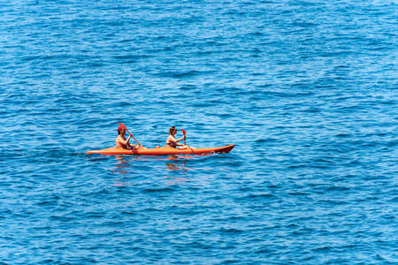 A man and a woman aboard an orange kayak, paddling in the blue Mediterranean sea, Gulf of La Spezia, Liguria, Italy, Europe.のeditorial素材