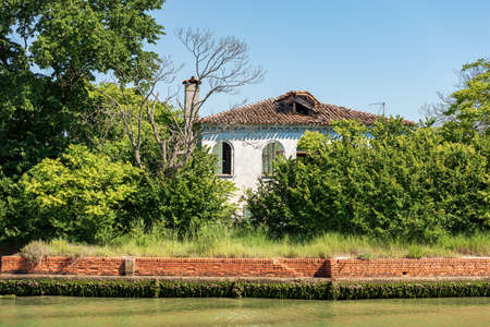 Abandoned and broken house in the Venice lagoon, partially hidden by vegetation. Venice, UNESCO world heritage site, Veneto, Italy, Europe.のeditorial素材
