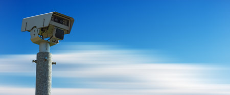 Closeup of a modern speed camera (traffic speed monitoring camera) against a clear blue sky in motion with copy space.の写真素材
