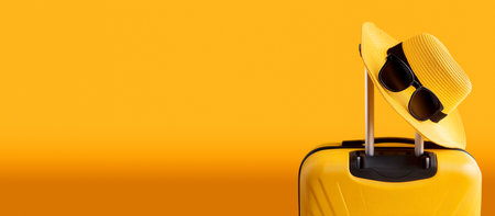 Orange and black suitcase or luggage bag with straw hat and sunglasses against a yellow-orange background with copy space. Holidays, weekend activities, relaxing time, traveling concept. Generative Aiの素材