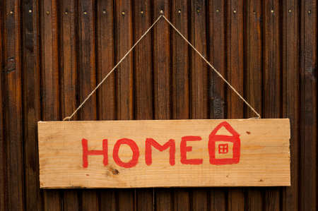 Home concept painted with red on a wood plank wich is hanging with string on a nailの写真素材