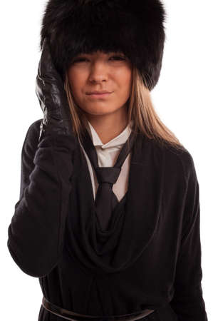 Beautiful woman with a headache wearing a fur hat, black gloves and tieの写真素材