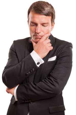 Real gentleman thinking at business while is wearing an elegant tuxedo, isolated on a white backgroundの写真素材