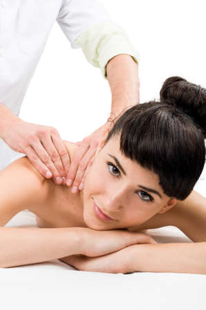 Relaxed female model looking into the camera while getting a massageの写真素材