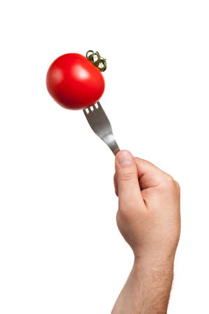 A fork stucked in a tomato hold by the cook's hand and everything on a white backgroundの写真素材