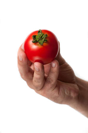 A perfect tomato with green top hold in a hand isolated on a white backgroundの写真素材