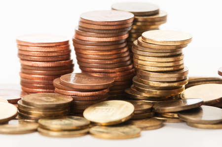 Closeup of piles of coins on white backgroundの写真素材
