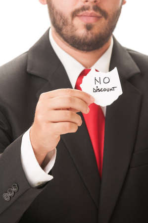 No discount concept using a man wearing a black suit and red necktie and holding a piece of paper with the text no discount on it.の写真素材