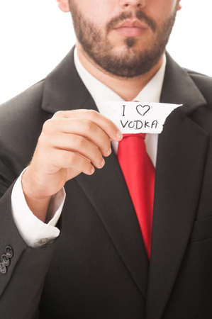 I love vodka concept using a man wearing a black suit and red necktie and holding a piece of paper with the text I love vodka on it.の写真素材
