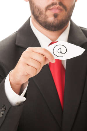 Email symbol concept using a man wearing a black suit and red necktie and holding a piece of paper with the email symbol on it.の写真素材
