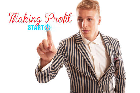 Start making profit concept using a man pressing the start button undet the making profit text. Isolated on white background.の写真素材