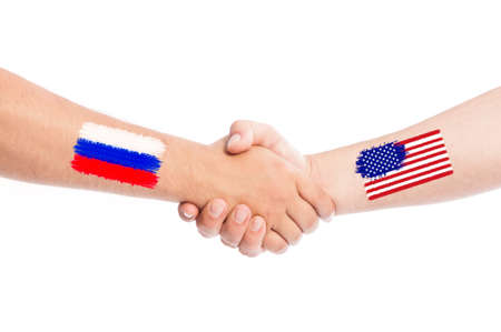 Russia and USA hands shaking with flags painted on arms concept. Isolated on white background.の写真素材