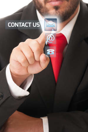 Contact us futuristic concept using elegant business man clicking button an high tech transparent touch screenの写真素材