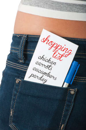 Shopping list concept using a paper card on the back pocket of a woman's blue jeansの写真素材