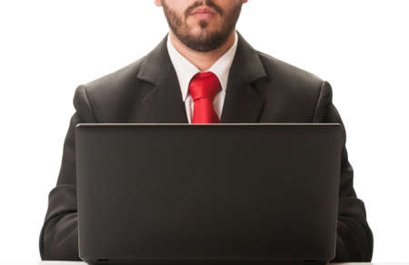 Business man working on laptop wearing a black suit and red tie.の写真素材